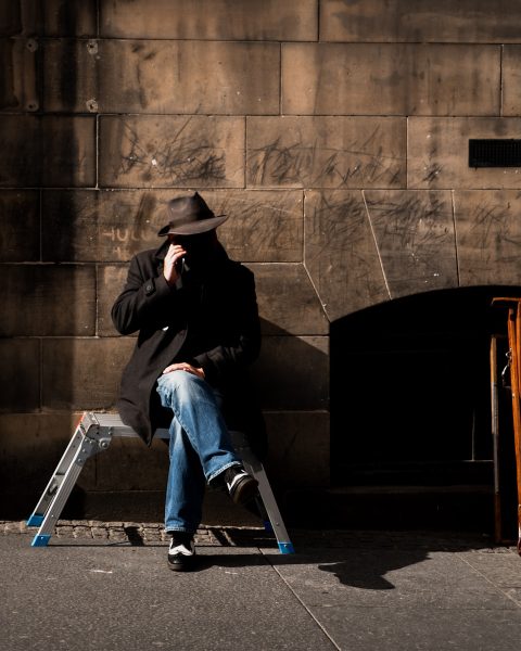 man sitting on stool near wall