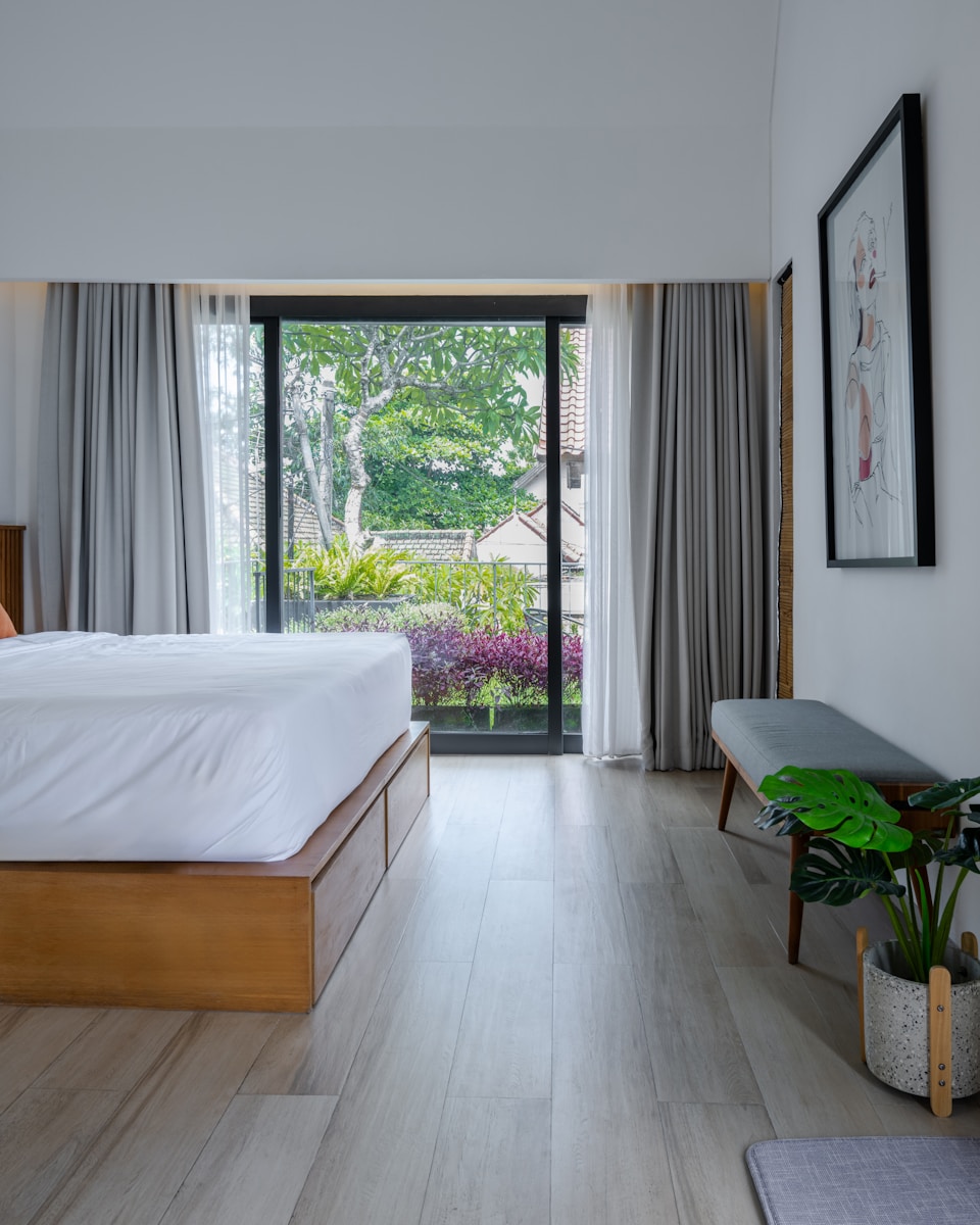 A bedroom with a large bed and a sliding glass door