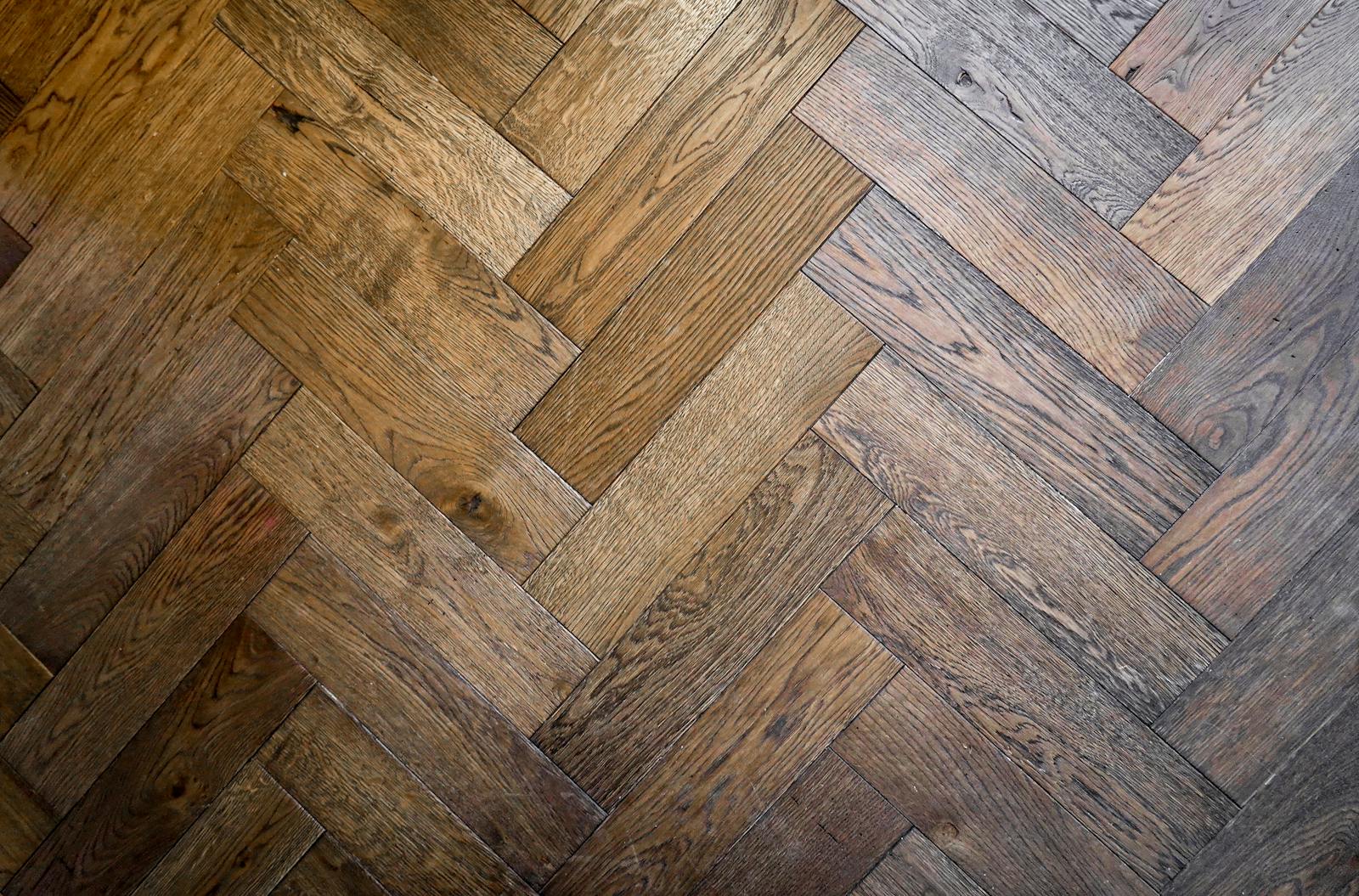 Stylish herringbone parquet floor pattern in warm wood tones, perfect for interior design inspiration.