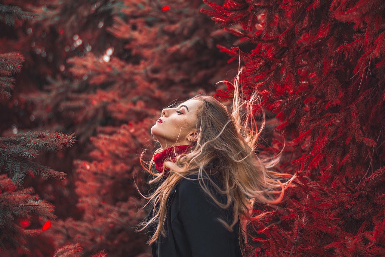 Vrouw in gelaagde herfstoutfit met lange cardigan over een lichte jurk en enkellaarzen