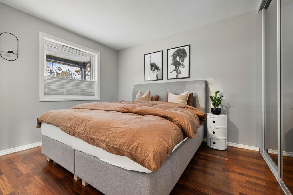 A bed sitting in a bedroom next to a window
