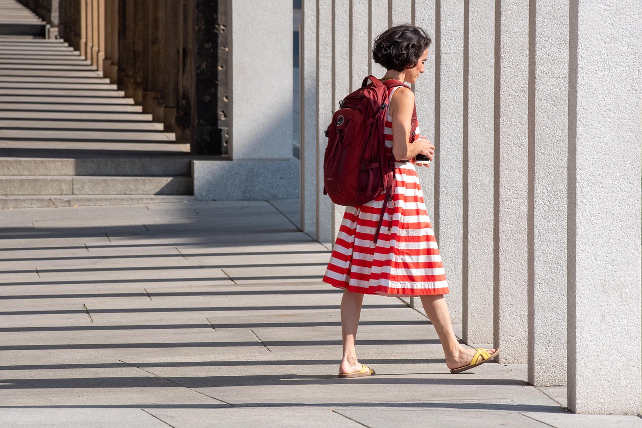Petite vrouw in een stijlvolle gelaagde outfit met open jas en verticale lijnen die het silhouet verlengen