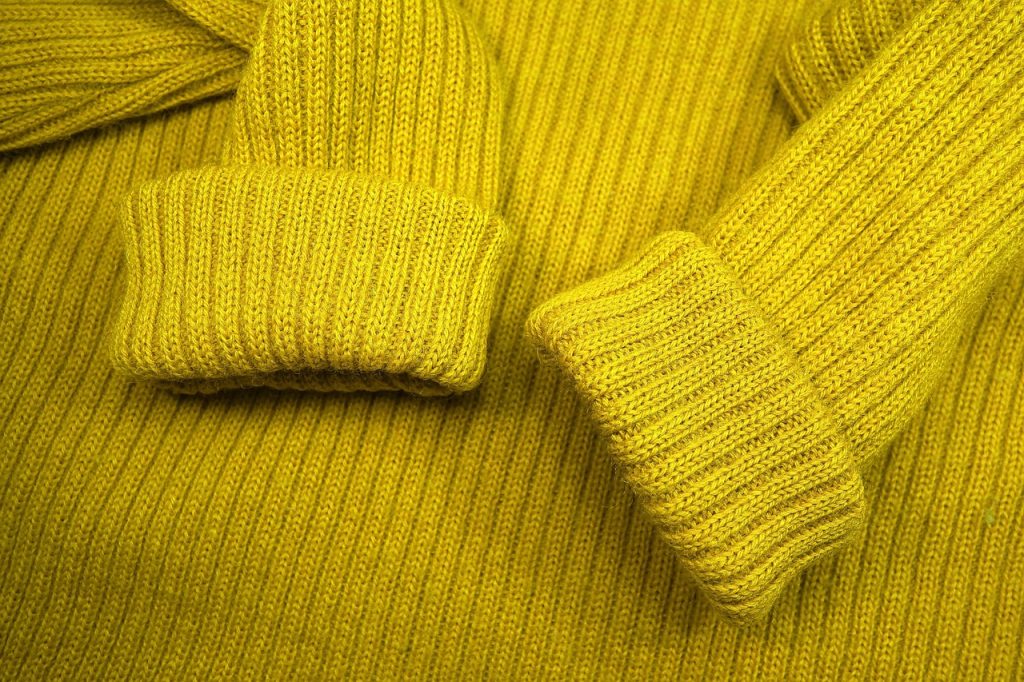 Close-up van pilletjes op een wollen trui langs de mouwnaad