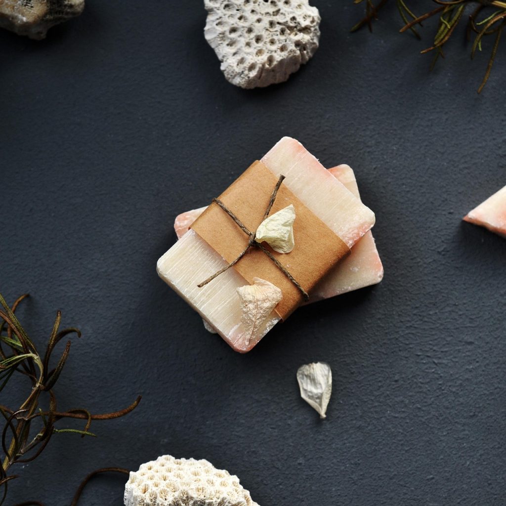 Een luxe geschenkmand gevuld met wellness producten zoals badolie, een kaars en een gezichtsmasker, mooi verpakt met tissue paper