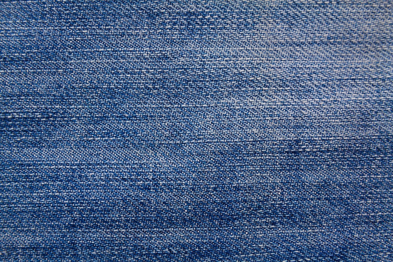 Vrouw die aandachtig de stof van een kledingstuk bekijkt in een winkel