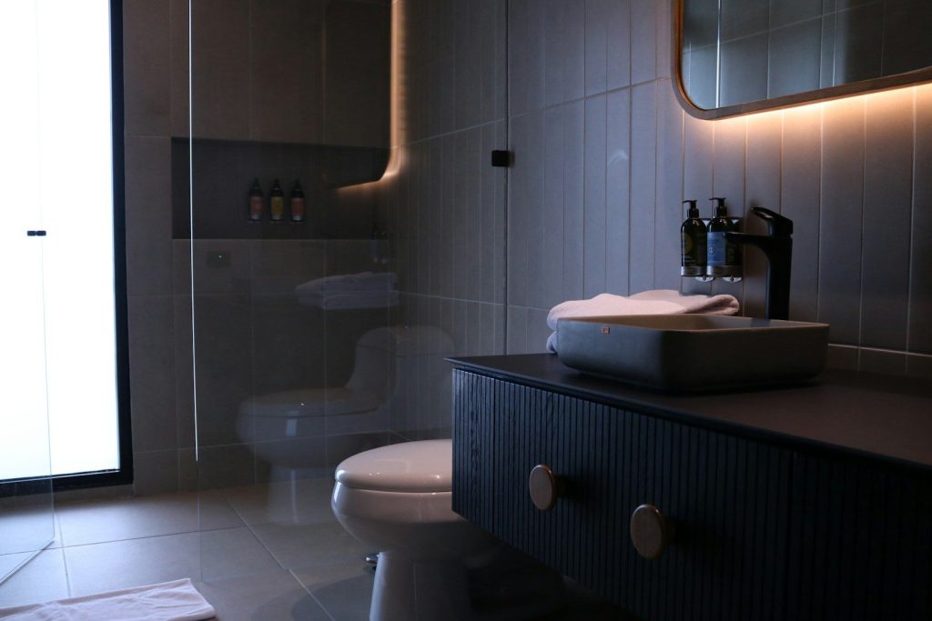 a bathroom with a toilet, sink and mirror